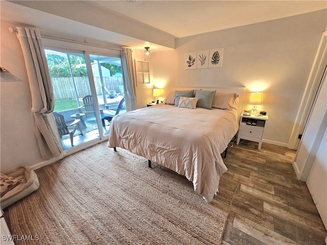 bedroom featuring multiple windows, access to outside, and dark hardwood / wood-style floors