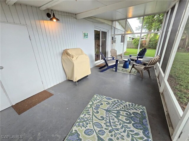 sunroom featuring beamed ceiling