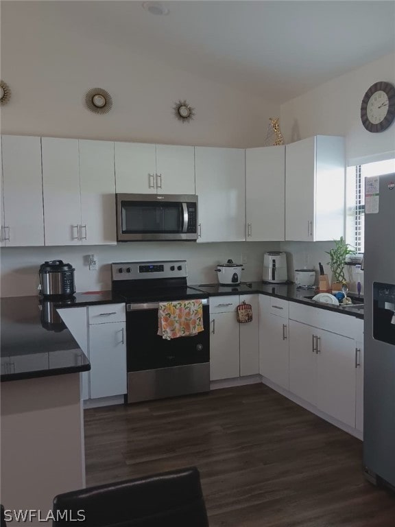 kitchen with appliances with stainless steel finishes, dark hardwood / wood-style flooring, and white cabinetry