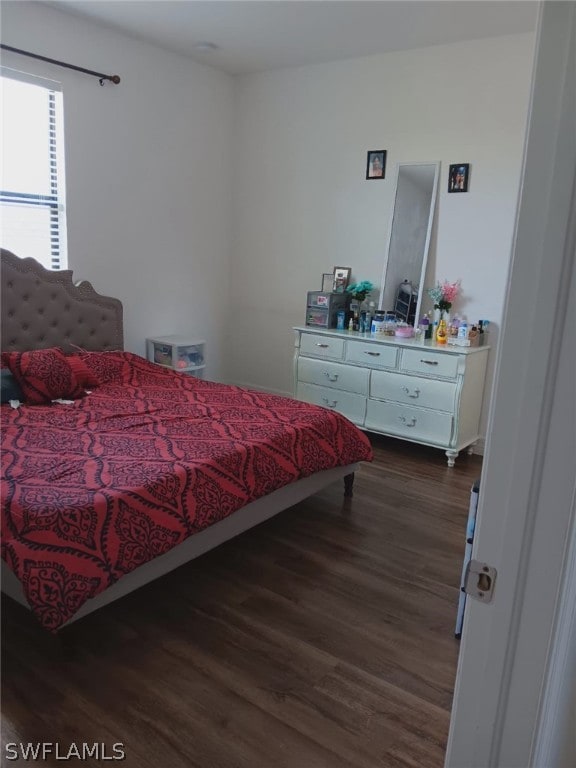 bedroom with dark hardwood / wood-style flooring