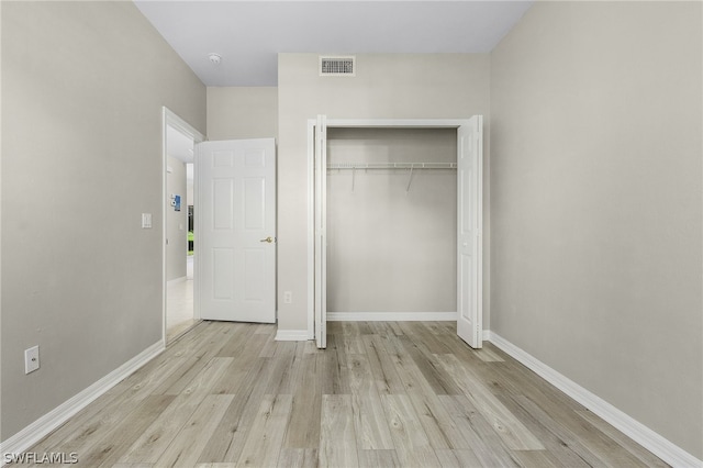 unfurnished bedroom featuring light hardwood / wood-style floors and a closet