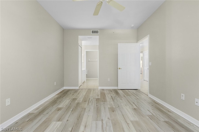 unfurnished bedroom with light wood-type flooring, ceiling fan, and connected bathroom