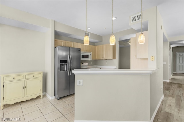 kitchen with light hardwood / wood-style floors, kitchen peninsula, hanging light fixtures, white appliances, and light brown cabinets