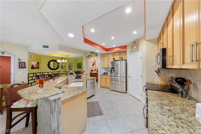 kitchen with light tile patterned flooring, decorative backsplash, appliances with stainless steel finishes, and light stone counters