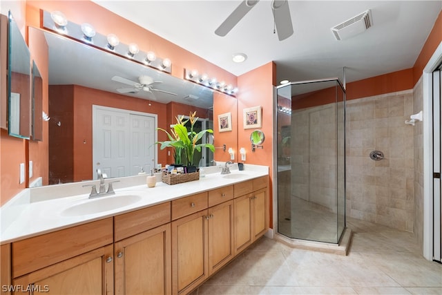 bathroom with a shower with shower door, ceiling fan, tile patterned floors, and double sink vanity