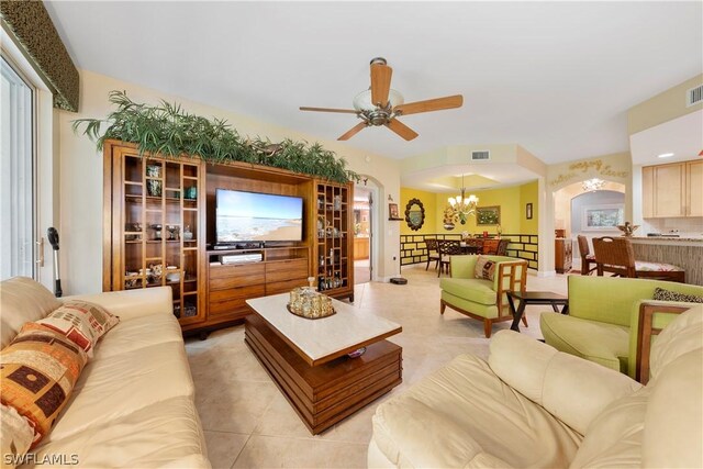 living room with ceiling fan with notable chandelier and light tile patterned floors