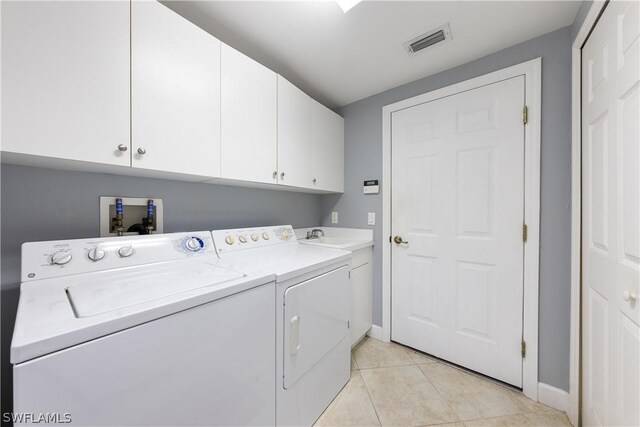 laundry area featuring light tile patterned flooring, independent washer and dryer, sink, and cabinets