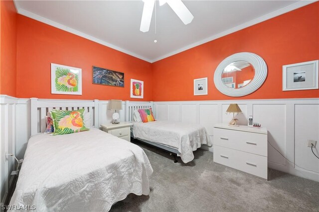 carpeted bedroom featuring ornamental molding and ceiling fan