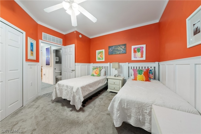 carpeted bedroom featuring ceiling fan, ornamental molding, and a closet