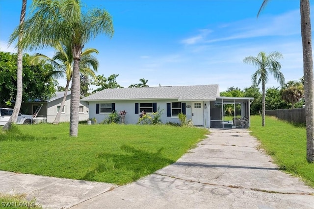 view of front of property with driveway, an attached carport, a front yard, and fence