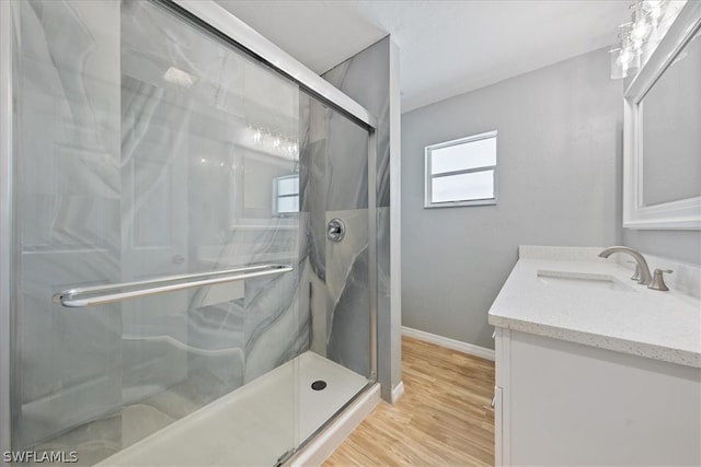 bathroom with vanity, an enclosed shower, and hardwood / wood-style floors