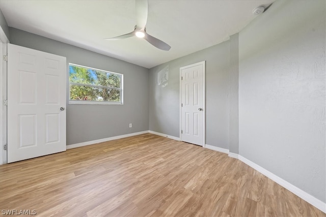 empty room with light hardwood / wood-style floors and ceiling fan