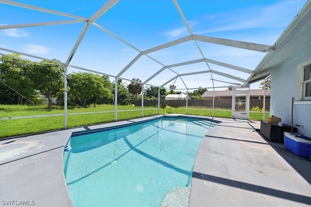 view of swimming pool with a yard, a patio area, and glass enclosure