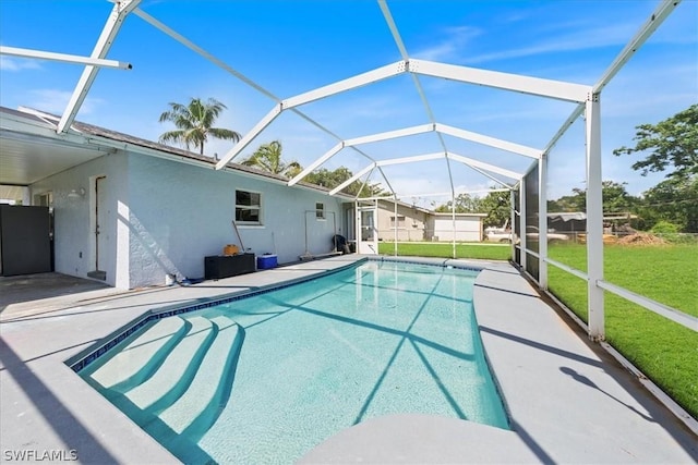 outdoor pool featuring a patio area, glass enclosure, and a lawn