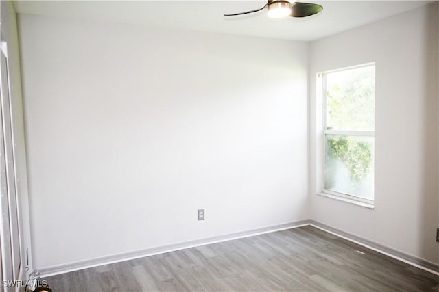 empty room with ceiling fan, hardwood / wood-style floors, and a healthy amount of sunlight