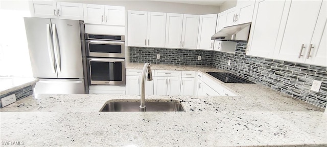 kitchen with light stone counters, sink, white cabinetry, and stainless steel appliances