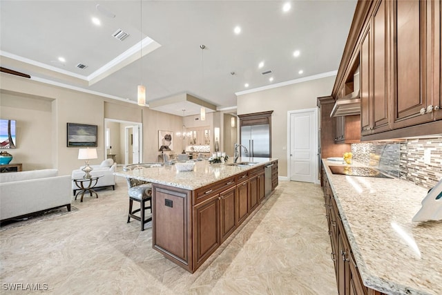 kitchen with crown molding, a large island, pendant lighting, a breakfast bar, and light stone counters