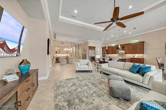 living room featuring ceiling fan with notable chandelier and ornamental molding