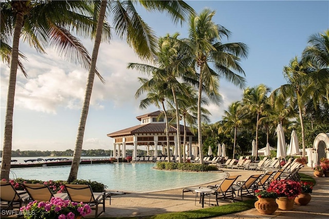 community pool with a patio area, a water view, and a gazebo