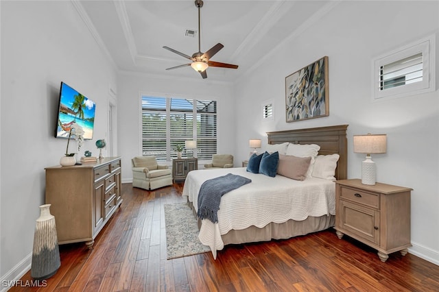 bedroom featuring dark wood-style floors, a tray ceiling, visible vents, ornamental molding, and baseboards