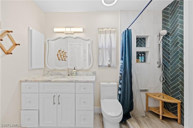 bathroom with curtained shower, wood-type flooring, vanity, and toilet