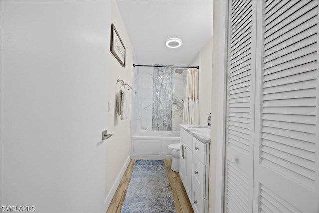 full bathroom with toilet, wood-type flooring, vanity, and shower / bath combo