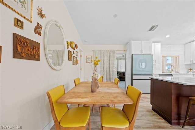 dining space featuring light hardwood / wood-style flooring and sink