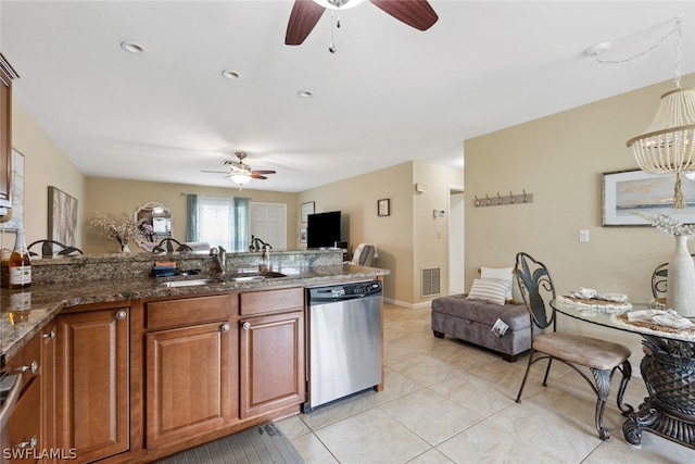 kitchen with light tile patterned floors, ceiling fan, dark stone countertops, dishwasher, and sink