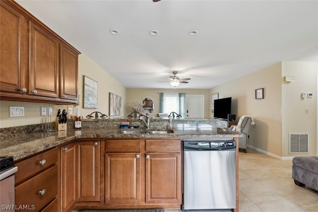 kitchen featuring dark stone counters, sink, ceiling fan, light tile patterned floors, and stainless steel dishwasher