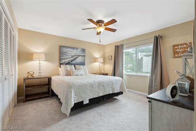 carpeted bedroom with ceiling fan and a closet