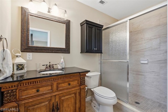 bathroom with vanity, toilet, and an enclosed shower