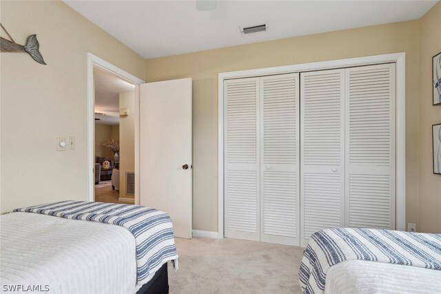 bedroom featuring light carpet and a closet