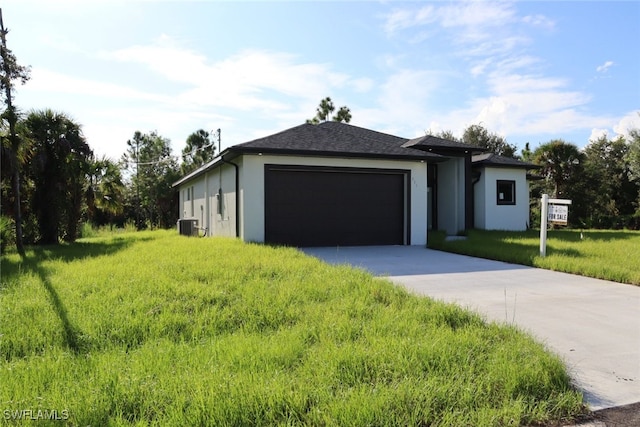 view of front facade featuring cooling unit, a garage, and a front lawn