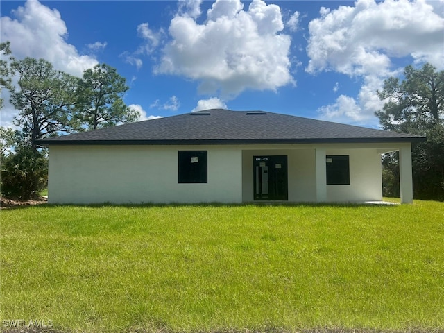 back of property featuring a lawn