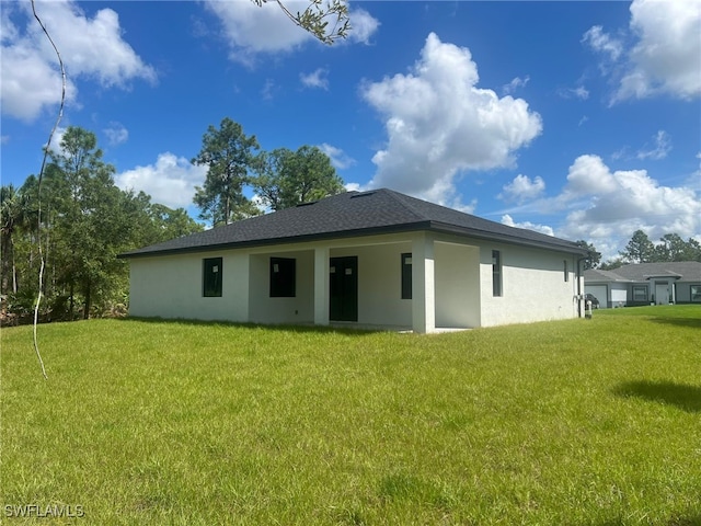 rear view of property featuring a yard