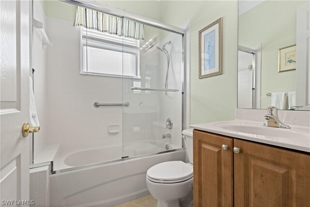 full bathroom featuring tile patterned flooring, enclosed tub / shower combo, toilet, and vanity