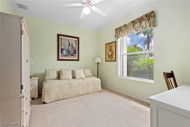 carpeted bedroom featuring ceiling fan and crown molding