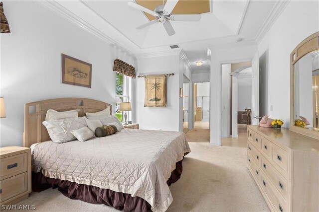 bedroom featuring a tray ceiling, light colored carpet, ceiling fan, and ornamental molding