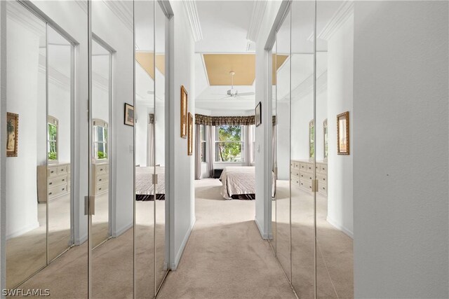 corridor with light colored carpet, a high ceiling, and ornamental molding