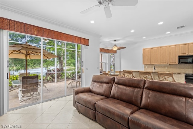 living room featuring crown molding, a healthy amount of sunlight, ceiling fan, and light tile patterned floors