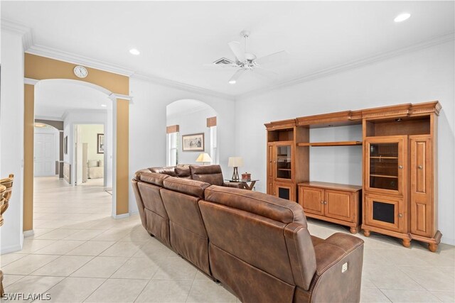 tiled living room with crown molding, decorative columns, and ceiling fan