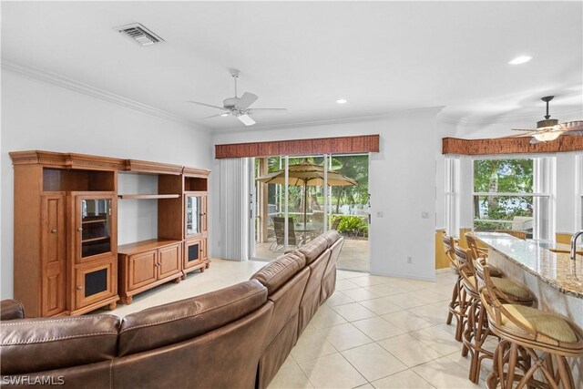 tiled living room featuring ceiling fan and crown molding