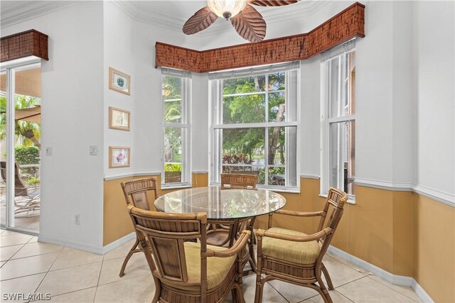 tiled dining area with crown molding and ceiling fan