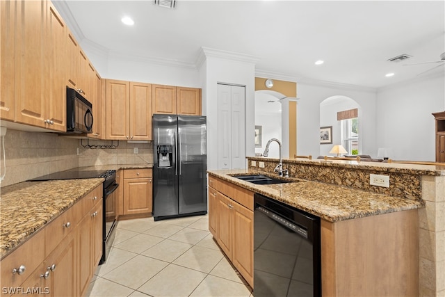 kitchen with a kitchen island with sink, black appliances, sink, and decorative backsplash