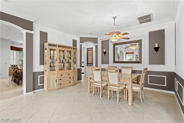 dining room with crown molding, light tile patterned flooring, and ceiling fan