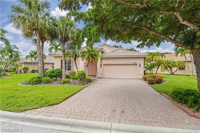 mediterranean / spanish-style home with a front lawn and a garage