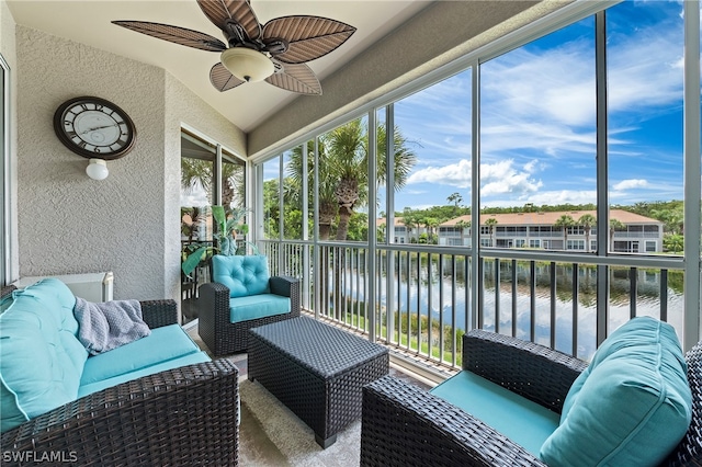 sunroom / solarium featuring a water view and ceiling fan