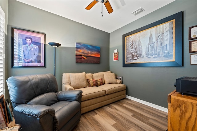 living room featuring wood-type flooring and ceiling fan