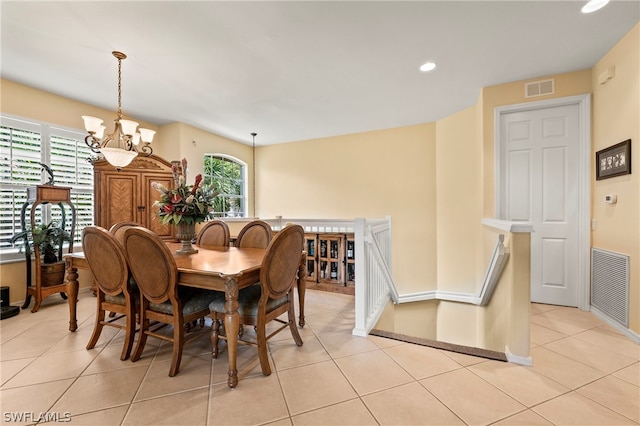 tiled dining space with a chandelier