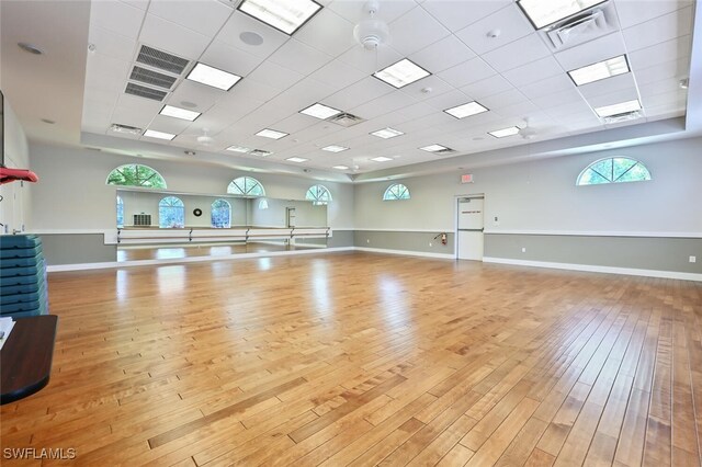 exercise area with a drop ceiling and light hardwood / wood-style floors